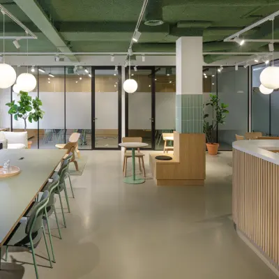 Modern office space for rent at Paradijslaan 30-38 in Eindhoven Center with contemporary furnishings, long tables, and potted plants.