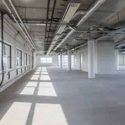 Spacious, industrial-style office interior at Professor Dr Dorgelolaan 14, Eindhoven Center, ideal for customization. Natural light floods through large windows, making it a suitable office space rental opportunity.