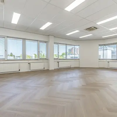 Spacious office space with large windows and parquet flooring at Croy 7, Eindhoven De Hurk, ideal for rent office space opportunities.