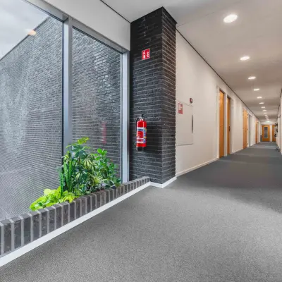 Spacious, well-lit hallway in an office building at Hurksestraat 60, Eindhoven De Hurk, available for office space rental.
