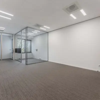 Empty office space with glass partition and neutral tones at Hurksestraat 60, ideal for office space rental in Eindhoven De Hurk.