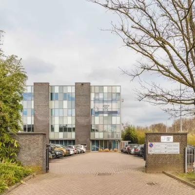 Exterior view of an office building at Hurksestraat 60, Eindhoven De Hurk, showing the entrance and parking area for office space rental.