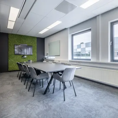 Modern office space with a long meeting table and chairs at Meerenakkerplein 1-10, Eindhoven De Hurk, ideal for office space rental.