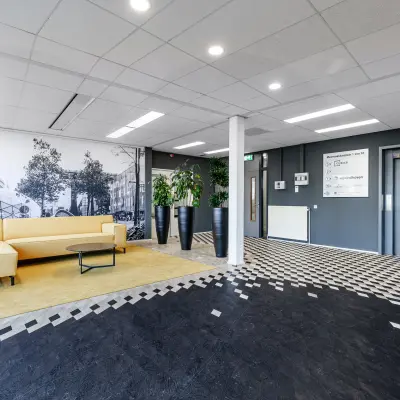 Spacious office lounge with modern decor at Meerenakkerplein 1-10, ideal for those seeking office space rental in Eindhoven De Hurk.