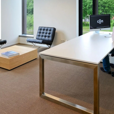 Modern office space at High Tech Campus 10, Eindhoven featuring sleek furniture with a professional working at a desk, ideal for office space rental.