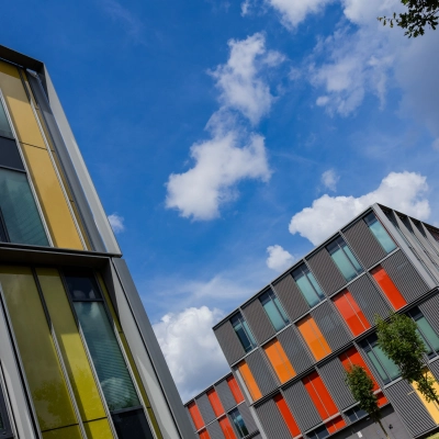 Exterior view of vibrant office buildings at High Tech Campus 9 in Eindhoven. Ideal location for office space rental, surrounded by a tech-centric environment with colorful architectural design.