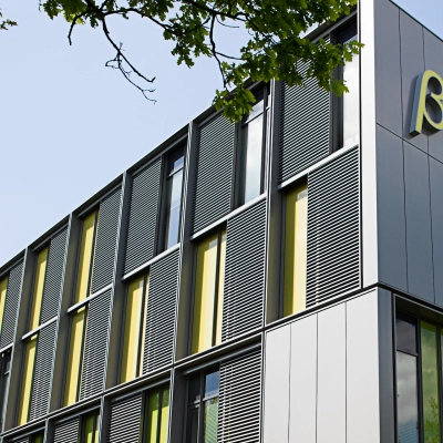 Modern exterior view of High Tech Campus 9, Eindhoven, featuring sleek designs and vibrant yellow accents. Ideal for office space rental in a prime technology hub.
