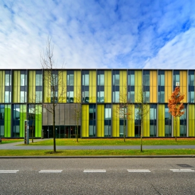 Colorful exterior of an office building located at High Tech Campus 9, Eindhoven, featuring a modern facade with vertical color panels. Ideal for office space rental in a vibrant tech environment.