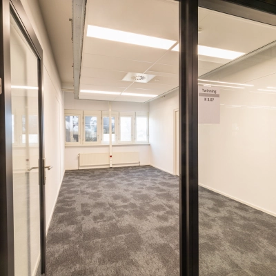 Unfurnished office space rental at TU campus De Zaale 11, Eindhoven High Tech Campus, featuring modern carpet and ample natural light from multiple windows.