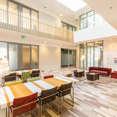 Bright office space with tables and chairs in a modern design, perfect for rent office space at TU campus Eindhoven High Tech Campus.