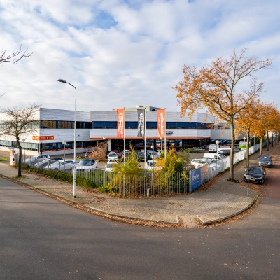 Exterior view of an office building at Tarasconweg 2, Eindhoven North, featuring ample parking space and a modern design. Ideal for those seeking office space rental in a convenient location.