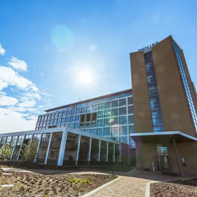 Exterior view of the office building at Achtseweg Zuid 159R, Eindhoven Strijp-S, showcasing a modern structure with clear skies, ideal for office space rental.