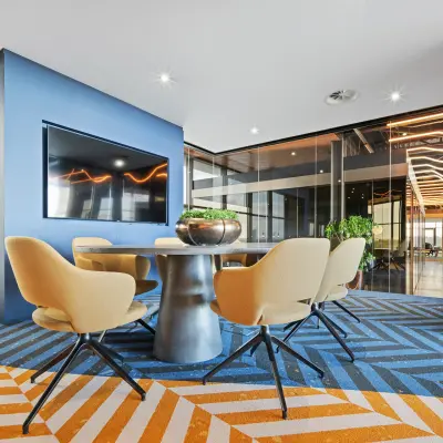 A modern meeting room with a sleek table, chairs, and a large TV in an office to rent at Achtseweg Zuid 159R, Eindhoven Strijp-S.