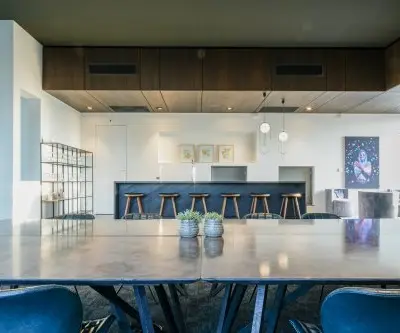 Chic office space rental in Eindhoven Strijp-S with a modern interior featuring a large table, stylish barstools, and contemporary decor at Achtseweg Zuid 159R.