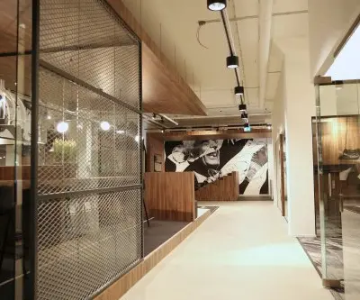 Modern office space at Frederiklaan 10E, Eindhoven Strijp-S, featuring artistic decor, glass walls, and seating areas available for office space rental.