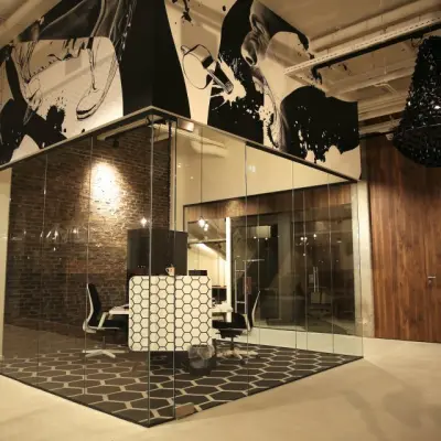 Modern office space at Frederiklaan 10E in Eindhoven Strijp-S with glass walls, stylish décor, and hexagonal flooring, available for office space rental.