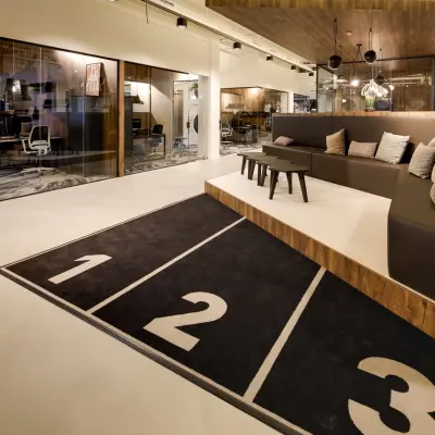 Modern office space for rent at Frederiklaan 10E, Eindhoven Strijp-S, featuring a stylish lounge area with seating and a unique runner-themed carpet.