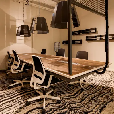 Spacious office to rent at Frederiklaan 10E, Eindhoven Strijp-S, featuring a modern conference room setup with a large wooden table and contemporary chairs.