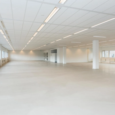 Spacious open floor plan with abundant natural light at Brandweerstraat 20-30, ideal for office space rental in Enschede. Minimalist design with ceiling lights and large windows.