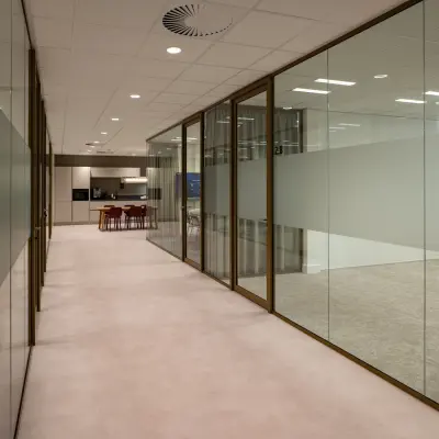 Modern office interior featuring glass walls, leading to a workspace area at Kuipersdijk 2-4, Enschede. Ideal for office space rental.