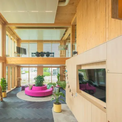 Bright, spacious office space at Moutlaan 1-23, Enschede, featuring a stylish interior with natural wood elements, modern furniture, and large windows enhancing the ambiance. Suitable for rent office space needs.