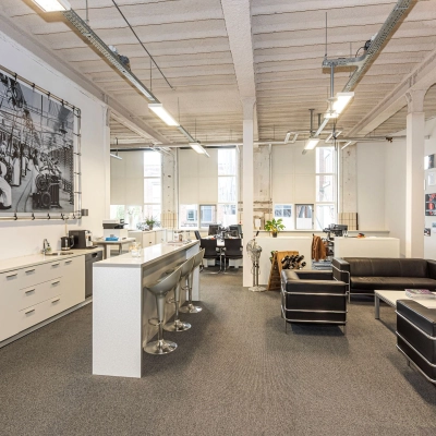 Modern office space in Enschede featuring comfortable seating, high ceilings, and natural light. Ideal for businesses seeking office space rental with stylish furnishings.