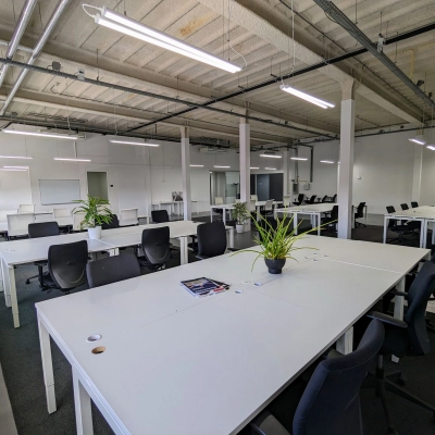 Spacious office interior at Rigtersbleek-Zandvoort 10, Enschede, featuring modern desks with chairs, plants, and bright lighting, ideal for office space rental.