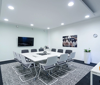 Modern office conference room at Mergenthaler Allee 15-21, Eschborn available for office space rental. Features a sleek table, comfortable chairs, and wall decor.
