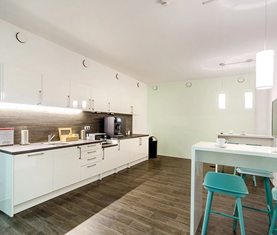 Bright office pantry at Mergenthaler Allee 15-21, Eschborn, ready for rent. Ideal for office space rental, featuring modern kitchen amenities and seating area.
