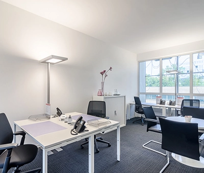 Bright office space to rent at Mergenthaler Allee 15-21, Eschborn, featuring modern furnishings and ample natural light from large windows.