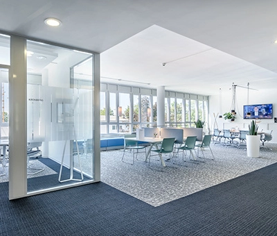Spacious office to rent at Mergenthaler Allee 15-21, Eschborn, featuring a bright, open floorplan with modern furniture and large windows.