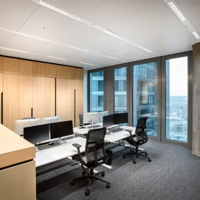 Modern office space in Junghofstraße 9, Frankfurt Center, featuring sleek workstations with large windows offering city views, ideal for office space rental.
