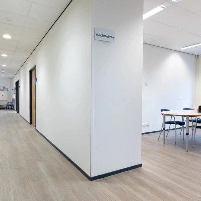 Interior office space at Zuidelijk Halfrond 1, Gouda featuring a hallway and a small furnished meeting area, ideal for office space rental.