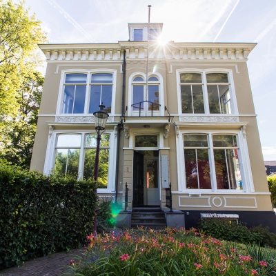 Exterior view of the office to rent at Prinsen Bolwerk 1, Haarlem Centraal Station, featuring a classic facade surrounded by greenery.