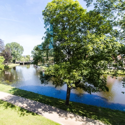 View of serene park with water feature near Prinsen Bolwerk 1, Haarlem Centraal Station, ideal for those seeking office space rental amidst nature.