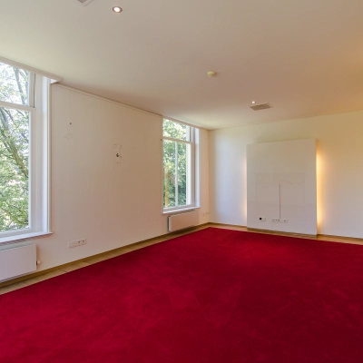 Spacious office with large windows and a red carpet at Prinsen Bolwerk 1, suitable for office space rental near Haarlem Centraal Station.