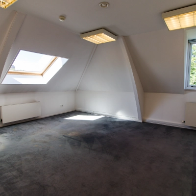 Bright, unfurnished office space available for rent at Prinsen Bolwerk 1, near Haarlem Centraal Station, featuring a large skylight and modern lighting.