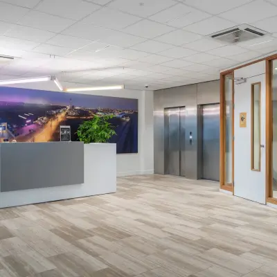 Modern office entrance with a reception desk and elevators at A. Hofmanweg 5A, Haarlem Waarderpolder. Ideal office space rental for businesses.
