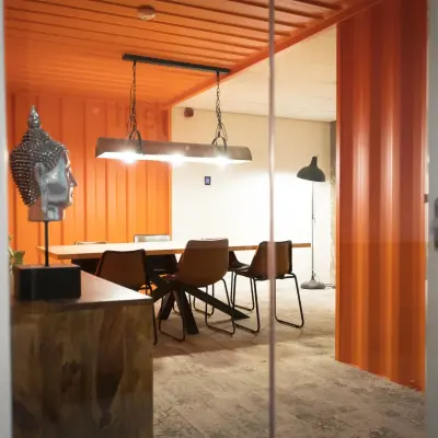 Modern office space with stylish orange accents and a meeting table at A. Hofmanweg 5A, Haarlem Waarderpolder, ideal for office space rental.