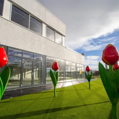 Exterior view of A. Hofmanweg 5A in Haarlem Waarderpolder, showing spacious outdoor area with decorative tulip sculptures. Ideal for businesses seeking office space rental.