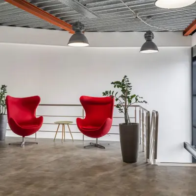 Stylish office space at Haarlem Waarderpolder with vibrant red chairs and plants offering a modern workspace environment suitable for office space rental.
