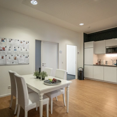 Interior view of a furnished office space at Raboisen 38, Hamburg Old Town, featuring a dining area and kitchenette, available for office space rental.