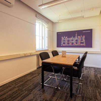 A modest, well-lit conference room in Harderwijk at Ceintuurbaan 2 featuring a table and chairs, suitable for small meetings. Ideal for those seeking office space rental.