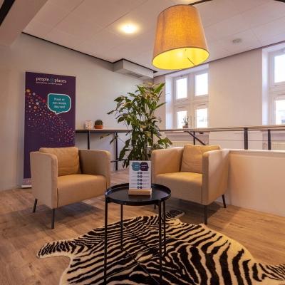 Cozy seating area with armchairs and a table on a zebra rug in an office located in Harderwijk, offering a welcoming space for office space rental.