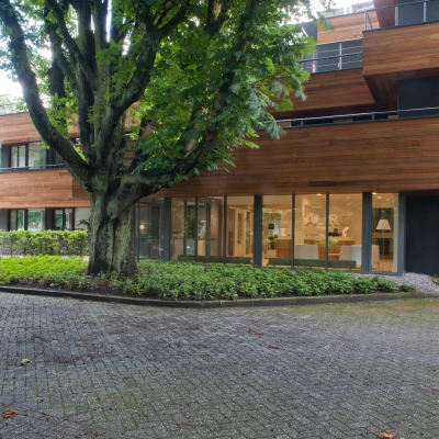 Exterior view of office to rent at Herenweg 115, Heemstede with modern architecture and surrounded by lush greenery.