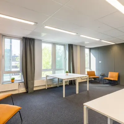 Bright office space to rent at Demmersweg 3 in Hengelo with modern furnishings, including desks and chairs, suitable for collaborative work.