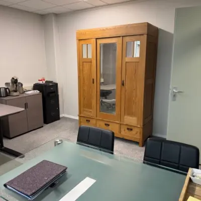 Furnished office space at Hamerstraat 10, Hengelo, featuring a glass table and wooden cabinet, available for office space rental.