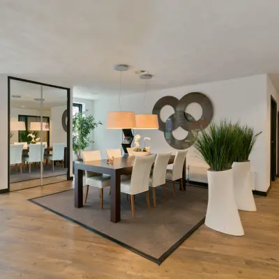 Contemporary office space at Welbergweg 60, featuring a polished meeting area with a wooden table, modern chairs, and vibrant greenery, available for rent.