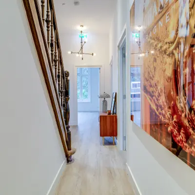 Bright hallway at Graaf Florislaan 40 in Hilversum, perfect for office space rental, featuring modern artwork and elegant staircase for a welcoming ambience.