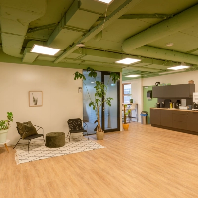 Furnished office space at Olympia 1 in Hilversum featuring a lounge area with chairs and plants, ideal for office space rental.